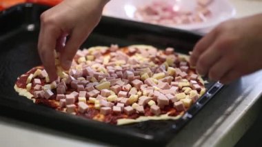 Çocuk el pizza hazırlamak. hamur üzerinde dolgu yaymak.