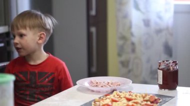 Çocuk el pizza hazırlamak. hamur üzerinde dolgu yaymak.