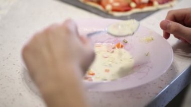 bir genç bir plaka bir kaşıkla bir çorba yiyor.