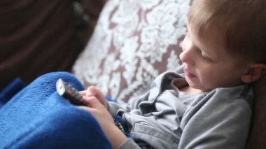 Çocuk Tv izliyor ve Uzaktan kumanda ile kanallar arasında geçiş yapma.