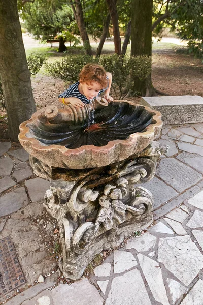 Bérgamo, Italia - 18 de agosto de 2017: Una chica desconocida bebe agua de una fuente . —  Fotos de Stock
