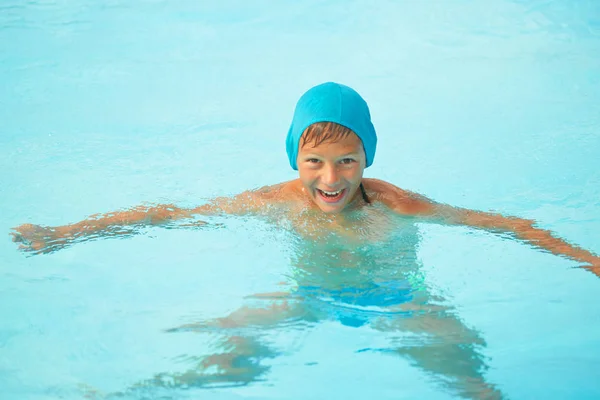 Adolescent dans une piscine extérieure avec un toboggan aquatique . — Photo