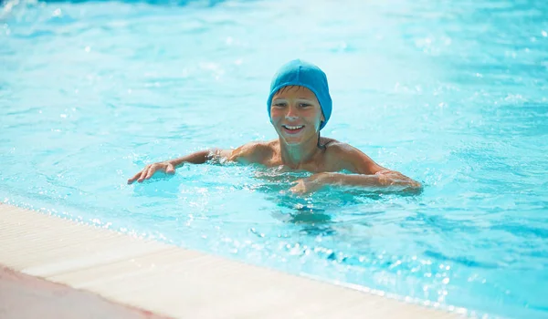 Adolescent dans une piscine extérieure avec un toboggan aquatique . — Photo