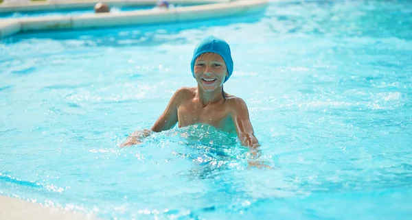 Adolescent dans une piscine extérieure avec un toboggan aquatique . — Photo