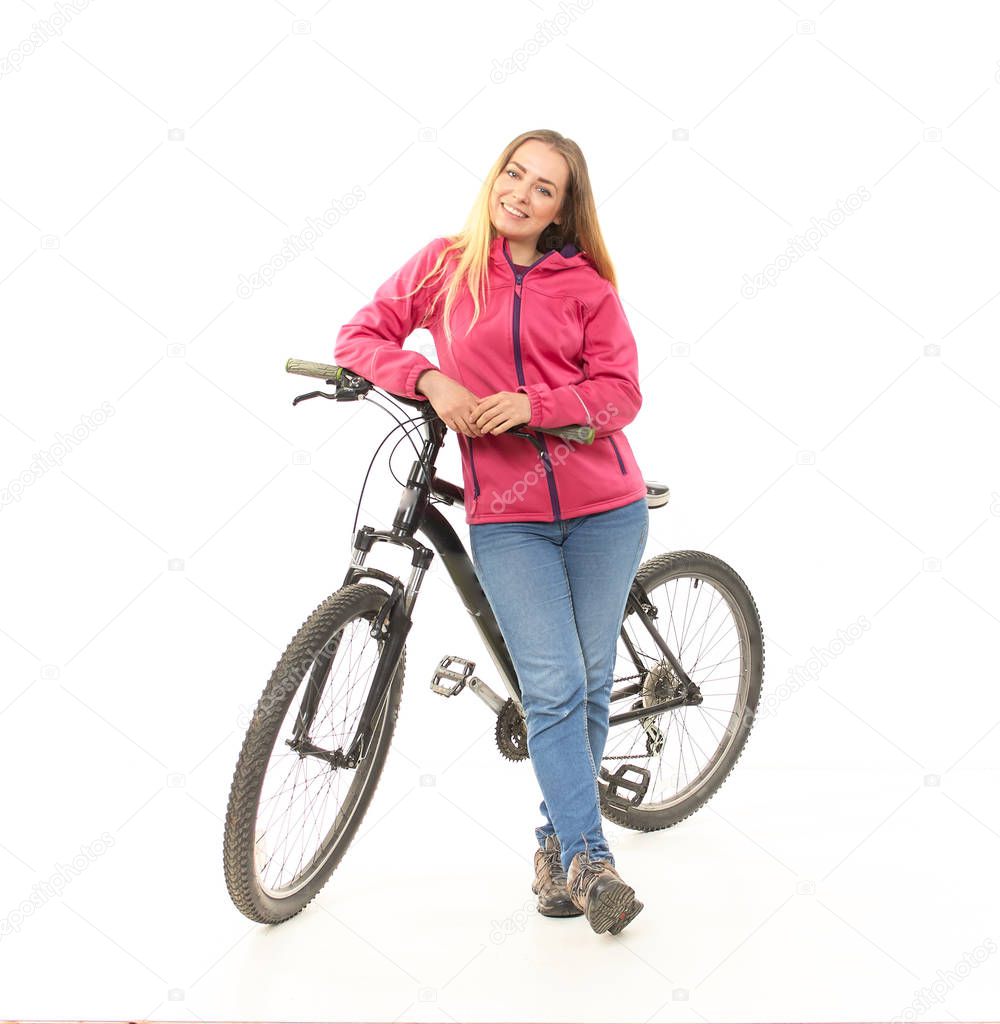 Girl in jeans on a bicycle on a white background.