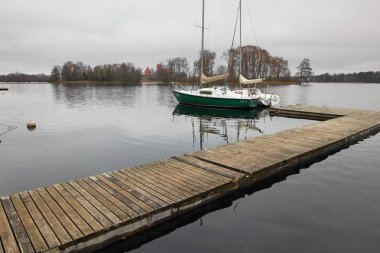 Trakai, Litvanya - 7 Kasım 2017: beyaz bir yat göl kenarında bir iskele üzerinde duruyor.