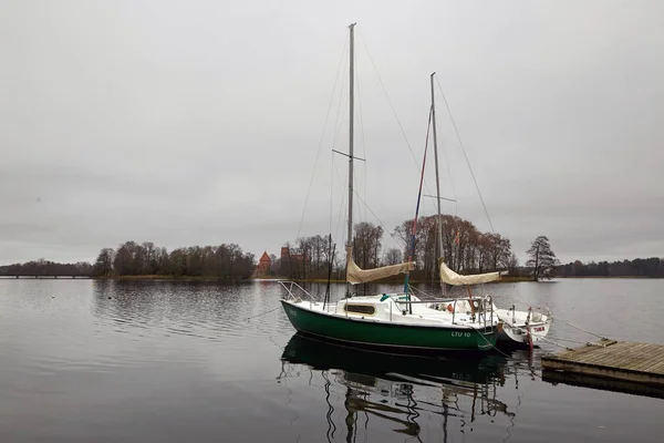 Trakai, Lituania - 7 de noviembre de 2017: un yate blanco se encuentra en un muelle en el lago . — Foto de Stock
