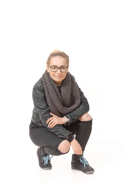 Una chica vestida con ropa de temporada baja en un snob sobre un fondo blanco . —  Fotos de Stock