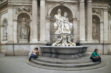 Vienna, Avusturya - 15 Nisan 2018: insanlar oturup çeşme anıt yakınındaki basamaklarda.