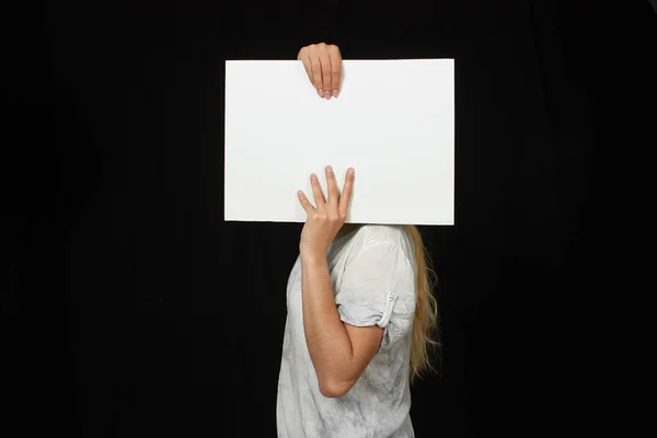 Mains féminines tenant une feuille de papier vierge isolée sur noir — Photo