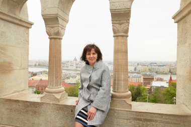 Kız bir korkuluk sütunlarla oturuyor.