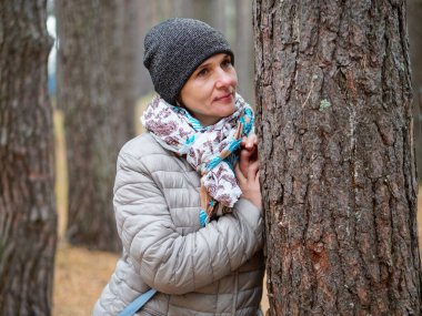 Sonbaharda açık havada çam ormanında bir kız.