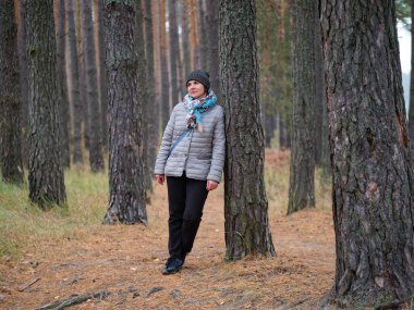 Sonbaharda açık havada çam ormanında bir kız.