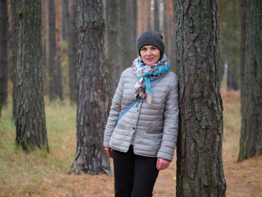 Sonbaharda açık havada çam ormanında bir kız.