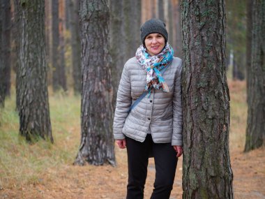 Sonbaharda açık havada çam ormanında bir kız.