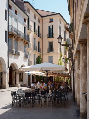 Vicenza, İtalya - 13 Ağustos 2019: Güneşli şemsiyeli açık hava kafe