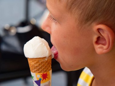 boy eats ice cream from a waffle cup
