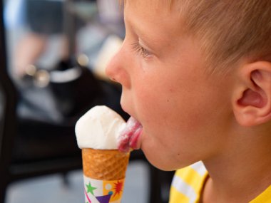 boy eats ice cream from a waffle cup