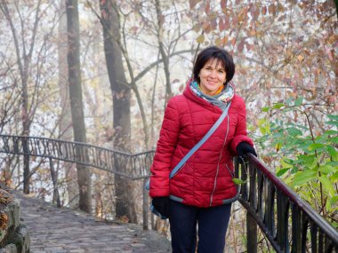 Sonbahar sisli parkında güzel neşeli bir kadın.