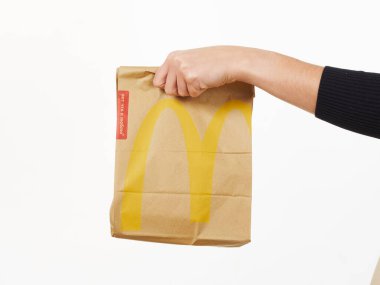 Gomel, Belarus 18 Kasım 2019: Beyaz arka planda McDonalds 'dan bir paket yiyecek bulunduruyor..