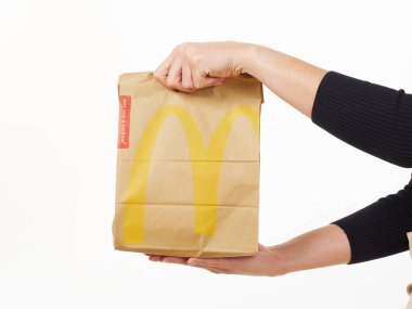 Gomel, Belarus 18 Kasım 2019: Beyaz arka planda McDonalds 'dan bir paket yiyecek bulunduruyor..