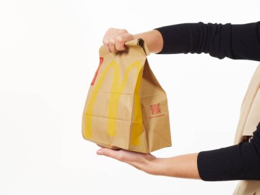 Gomel, Belarus 18 Kasım 2019: Beyaz arka planda McDonalds 'dan bir paket yiyecek bulunduruyor..