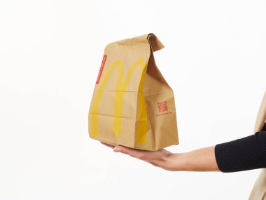 Gomel, Belarus 18 Kasım 2019: Beyaz arka planda McDonalds 'dan bir paket yiyecek bulunduruyor..