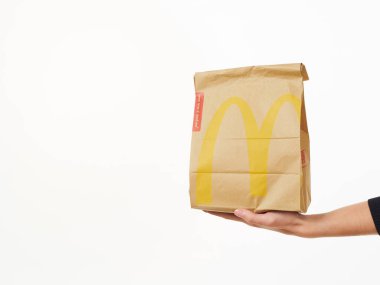 Gomel, Belarus 18 Kasım 2019: Beyaz arka planda McDonalds 'dan bir paket yiyecek bulunduruyor..