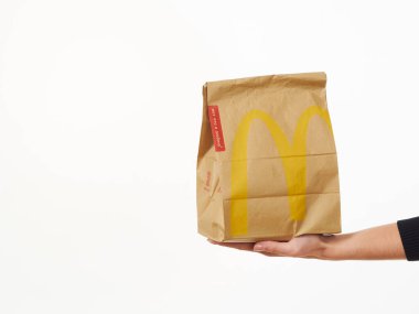 Gomel, Belarus 18 Kasım 2019: Beyaz arka planda McDonalds 'dan bir paket yiyecek bulunduruyor..