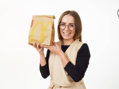 Gomel, Belarus 18 Kasım 2019: Beyaz arka planda McDonalds 'dan bir paket yiyecek bulunduruyor..