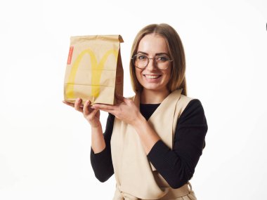Gomel, Belarus 18 Kasım 2019: Beyaz arka planda McDonalds 'dan bir paket yiyecek bulunduruyor..