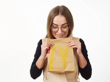Gomel, Belarus 18 Kasım 2019: Beyaz arka planda McDonalds 'dan bir paket yiyecek bulunduruyor..