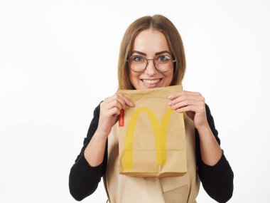 Gomel, Belarus 18 Kasım 2019: Beyaz arka planda McDonalds 'dan bir paket yiyecek bulunduruyor..