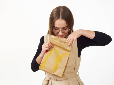 Gomel, Belarus 18 Kasım 2019: Beyaz arka planda McDonalds 'dan bir paket yiyecek bulunduruyor..
