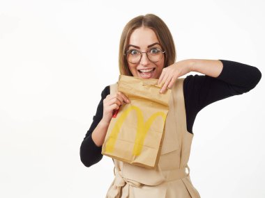 Gomel, Belarus 18 Kasım 2019: Beyaz arka planda McDonalds 'dan bir paket yiyecek bulunduruyor..