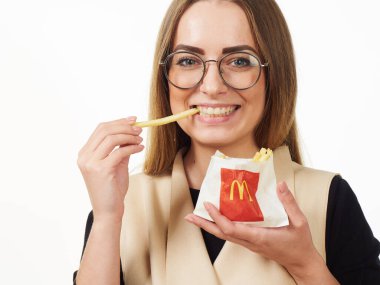 Gomel, Belarus 18 Kasım 2019: Beyaz bir arka planda McDonalds 'dan bir paket patates kızartması bulunduruyor..