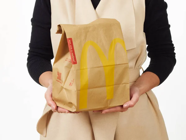 GOMEL, BELARUS NOVEMBER 18, 2019: girl holds a packet of food from McDonald's on a white background. — Stock Photo, Image