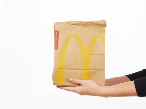 Homel, Białoruś 18 listopada 2019: dziewczyna trzyma paczkę jedzenia od McDonalda na białym tle. — Zdjęcie stockowe