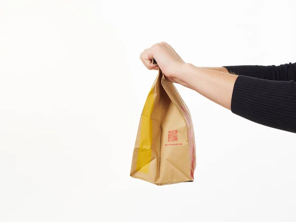 GOMEL, BELARUS NOVEMBER 18, 2019: gadis memegang paket makanan dari McDonald 's dengan latar belakang putih . — Stok Foto