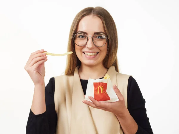 GOMEL, BELARUS NOVEMBER 18, 2019: girl holds a packet with French fries from McDonald's on a white background. — Stock Photo, Image
