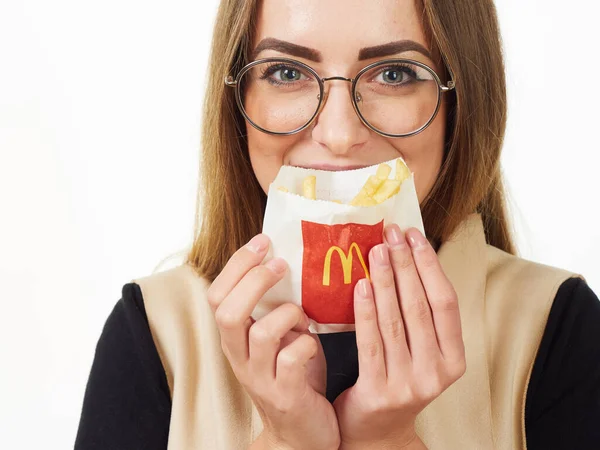 Gomel, Bělorusko 18. listopadu 2019: dívka drží balíček s hranolkama od McDonalda na bílém pozadí. — Stock fotografie