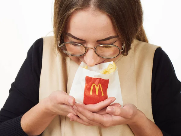 GOMEL, BELARUS NOVEMBER 18, 2019: gadis memegang paket dengan kentang goreng dari McDonald 's dengan latar belakang putih . — Stok Foto