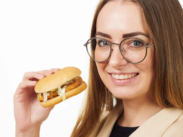 Girl eating a burger on a white background — Stock Photo, Image