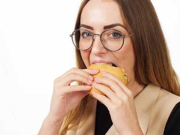 Девушка ест бургер на белом фоне — стоковое фото