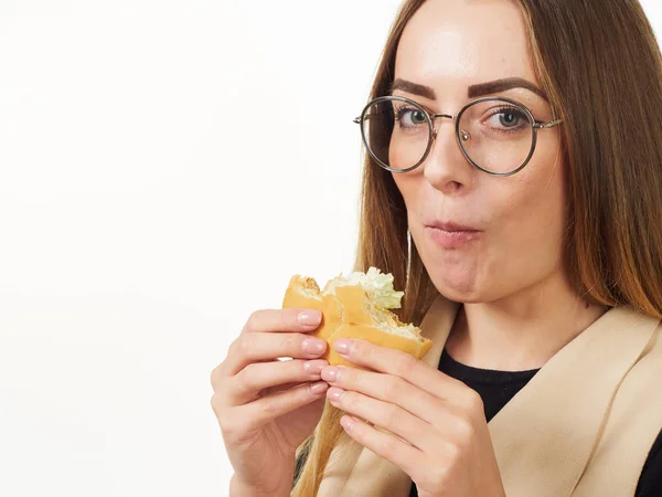 Girl eating a burger on a white background — Stock Photo, Image