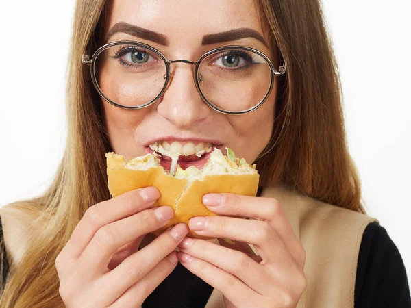 Girl eating a burger on a white background — Stock Photo, Image