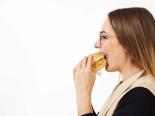 Gadis makan burger di latar belakang putih — Stok Foto