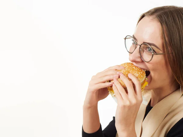 Chica comiendo una hamburguesa sobre un fondo blanco — Foto de Stock
