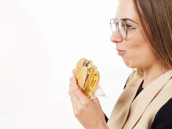 Chica comiendo una hamburguesa sobre un fondo blanco — Foto de Stock