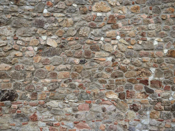 Stenen muur van de oude stad met groene wijnstokken — Stockfoto
